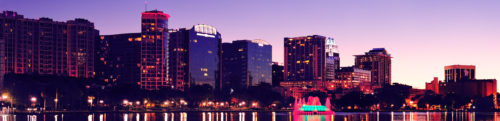 Orlando downtown skyline panorama silhouette over Lake Eola at dusk with urban skyscrapers.
